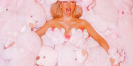 Shirin David liegt zwischen einer großen Menge weiß-rosa Teddybären