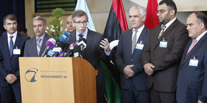Männer, darunter Bernardino Leon, und weitere libysche Politiker stehen hinter einem Pult