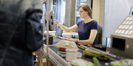 Eine junge Frau arbeitet als Kassiererin im Supermarkt