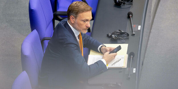 Finanzminister Christian Lindner mit seinem Mobiltelefon im Deutschen Bundestag