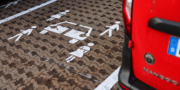 Ein Logo mit einem Auto und vier Fahrgästen weist auf einen für ein Auto des Car-Sharing-Anbieters Teilauto reservierten Parkplatz hin