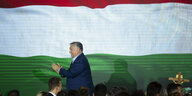 Orbán klatscht vor einer riesigen ungarischen Fahne