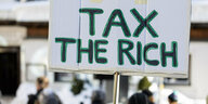 Schild mit dem Schrifttzug "tax the rich"