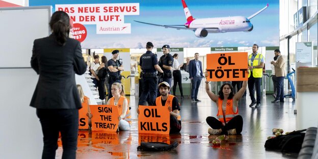 Klimaaktivisten der Gruppe Letzte Generation Österreich verschütten im Terminal 3 des Flughafen Wien Farbe um gegen die aktuelle Klimapolitik der österreichischen Regierung zu protestieren