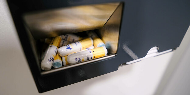 Ein Spender mit Tampons auf einer Unisex-Toilette