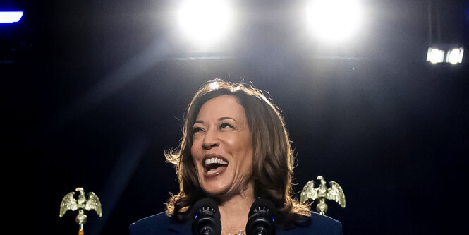 Kamala Harris lacht auf der Bühne während eines Wahlkampfauftritts