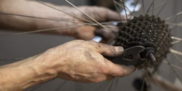 Eine Nahaufnahme von einer Hand die ein Fahrradritzel abschraubt