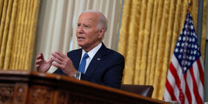 Joe Biden gestikuliert am Schreibtisch im Oval Office