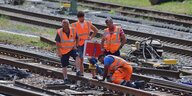 Menschen in orangen Westen bei Gleisarbeiten