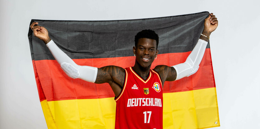 Basketballer Dennis Schröder mit Fahne.