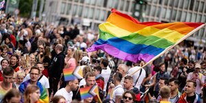 Ganz viele Menschen mit einer Regenbogenfahne über ihren Köpfen beim der 45. Berlin Pride-Parade zum Christopher Street Day (CSD) im Jahr 2023