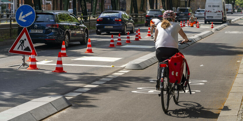 Fahrrdfahrende Person auf Radweg mit Beton-Schutzelementen