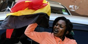 Kampala: Eine Demonstrantin hält die Nationalfahne Ugandas während eines Protests gegen Korruption.