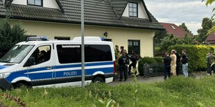 Polizeiwagen steht vor einem Haus