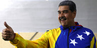 In die venezolanische Fahne gehüllt reckt Nicolás Maduro die rechte Hand in die Höhe
