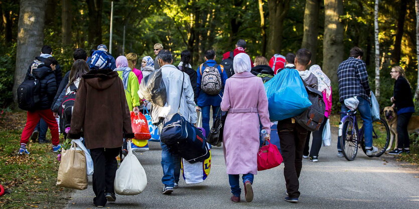 Eine Gruppe von Menschen ist von hinten auf einer Straße laufend zu sehen