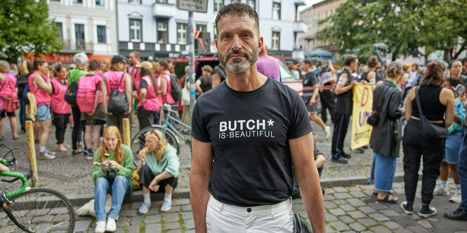 Eine Demo im Hintergrund, vorn steht ein Mann und schaut in die Kamera: Alfonso Pantisano zeigt sich oft in der Öffentlichkeit, wie hier am 26. Juli 2024 am Rande des Dyke* Marches