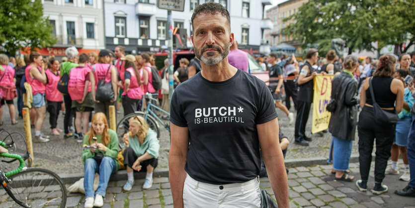 Eine Demo im Hintergrund, vorn steht ein Mann und schaut in die Kamera: Alfonso Pantisano zeigt sich oft in der Öffentlichkeit, wie hier am 26. Juli 2024 am Rande des Dyke* Marches