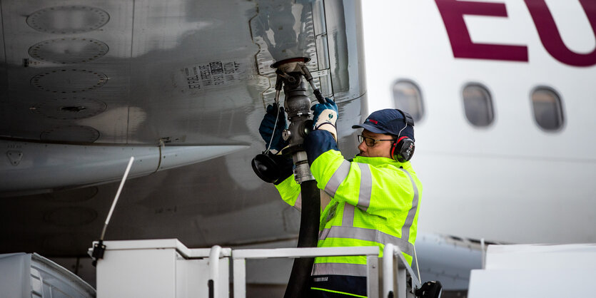 Ein Arbeiter betankt ein Flugzeug