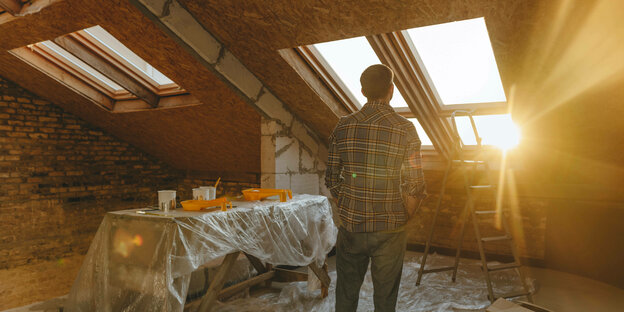 die Sonne scheint durch Dachfenster, isoliertes Dach, Handwerkszeug auf Tisch, Leiter