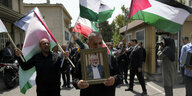 Ein Trauermarsch. Im Vordergrund hält ein Mann ein Bild des getöteten Hamas-Führers ins Bild