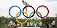 Ein Sportler klettert auf die Olympischen Ringe