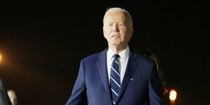 Joe Biden steht im Scheinwerferlicht und hält eine Rede