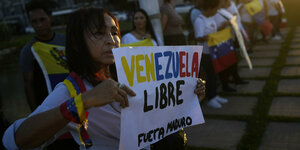 Eine Frau hält ein Schild auf dem Free Venezuela- Freies Venezuela und Fuerta Maduro - Maduro raus steht