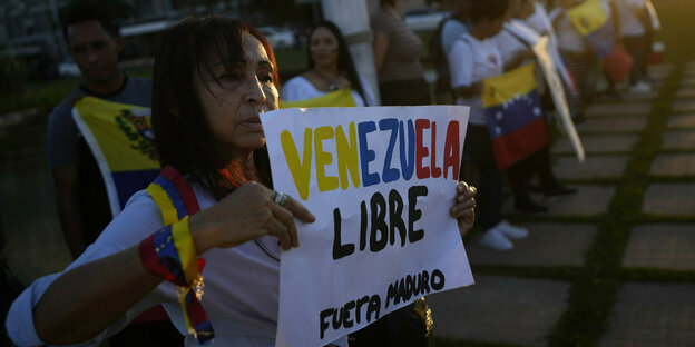 Eine Frau hält ein Schild auf dem Free Venezuela- Freies Venezuela und Fuerta Maduro - Maduro raus steht