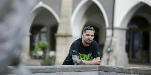 David Teschner lehnt in der Görlitzer Altstadt an einem Brunnen vor einem Arkadengang