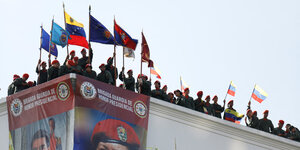 Militärs mit venezuelanischen Flaggen auf einem Dach