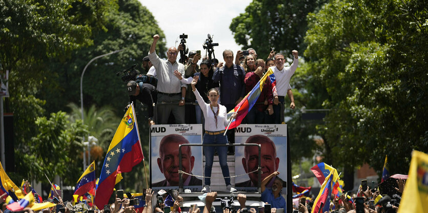 Oppostionsführerin María Corina Machado auf einem Demonstrationszug mit eienr FAhne