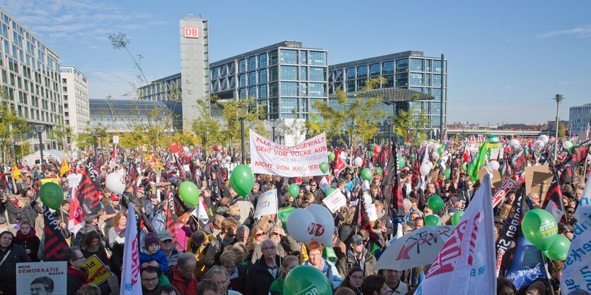 viele Menschen mit Ballons und Transparenten vor dem Berliner Hauptbahnhof