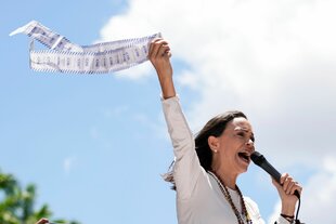 María Corina Machado spricht in ein Mikrofon