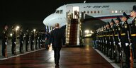 Wladimir Putin auf dem Weg zum Flugzeug auf einem roten Teppich, in dem seine freigelassenen Gefangen sitzen. Soldaten stehen Spalier.