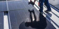 Ein Solarpanel, in dem sich ein Mensch spiegelt