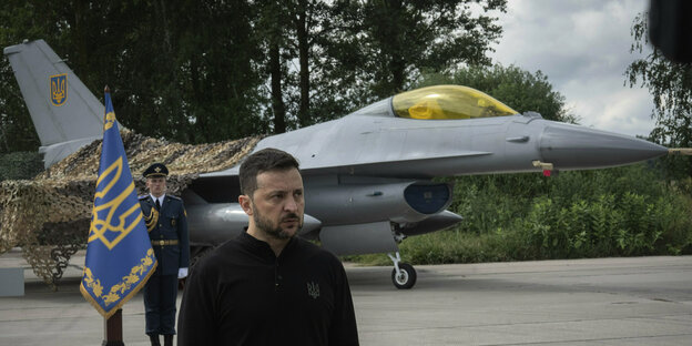Präsident Selenskyj vor einem Kampfflugzeug.