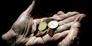 Eine 83-jährige Frau hält verschiedene Euromünzen in den Händen