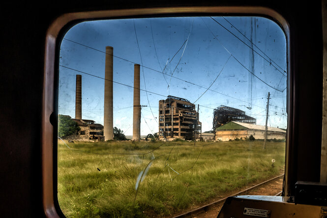 Ruinen einer Fabrik durch ein Bahnfenster gesehen