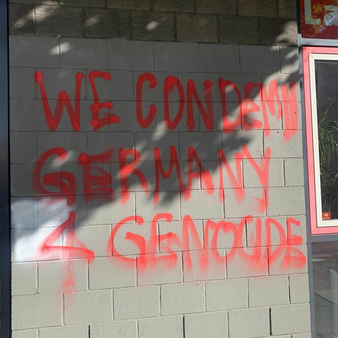 Auf einer Hauswand steht mit roter Farbe "WE CONDEMN GERMANY FOR GENOCIDE"