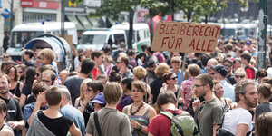 Bild von einer Demonstration, auf der ein Schild mit der Aufschrift "Bleiberecht für alle" gezeigt wird.
