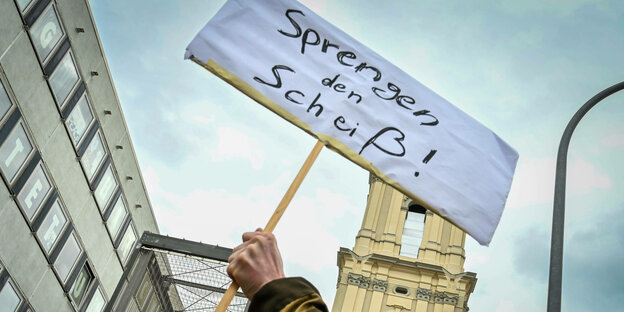 Protest mit einem Schild vor der Garnisonkirche.