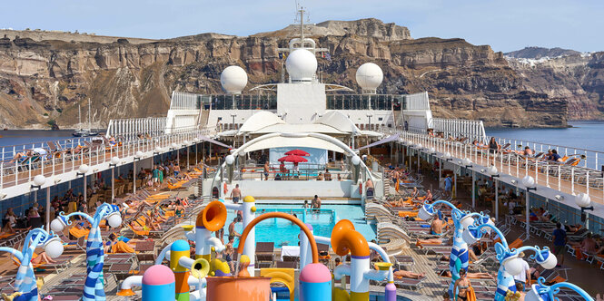 Ein Kreuzfahrtschiff mit Urlaubern vor der Insel Santorin in Griechenland