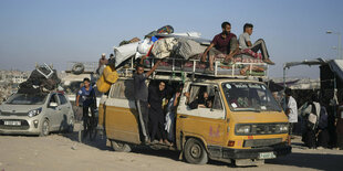 Ein gelber Bus ist voll beladen mit Menschen