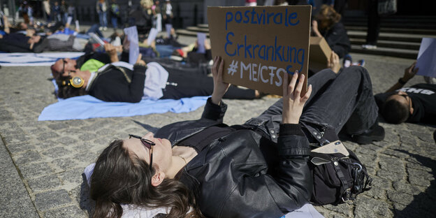 Bei einer Liegend-Demonstration machen etwa fünfzig Demonstranten vor dem Roten Rathaus in Berlin aufmerksam auf die ME/CFS-Erkrankung.