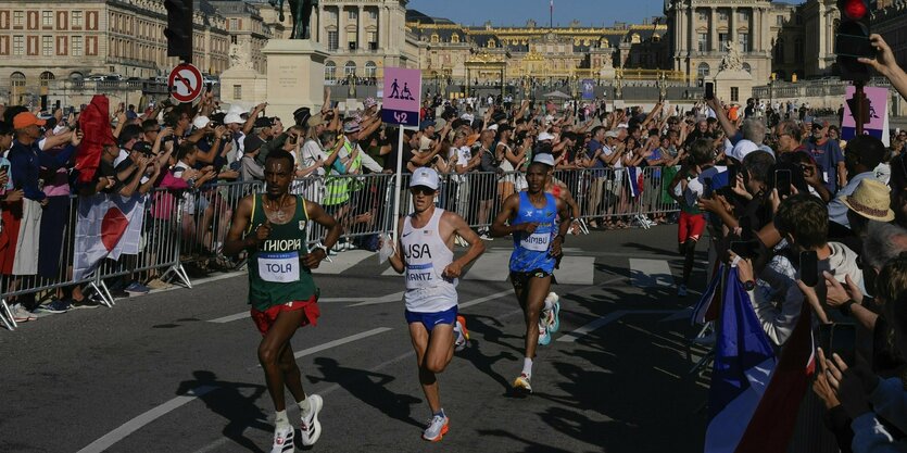 Marathonläufer auf der Strecke, viele Zuschauer am Straßenrand