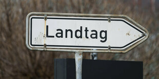 Ein Straßenschild mit der Aufschrift "Landtag" weist nach rechts.