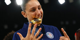 Die Sportlerin Diana Taurasi beißt auf ihre Goldmedaille.