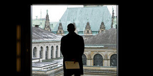 Ein Mann schaut aus dem Hamburger Rathaus auf die Börse, den Sitz der Handelskammer.