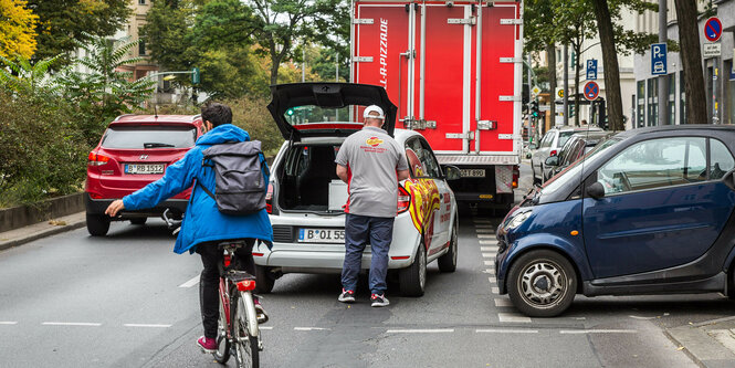 Ein Radfhrer auf einer vom Verkehr blockierten Straße